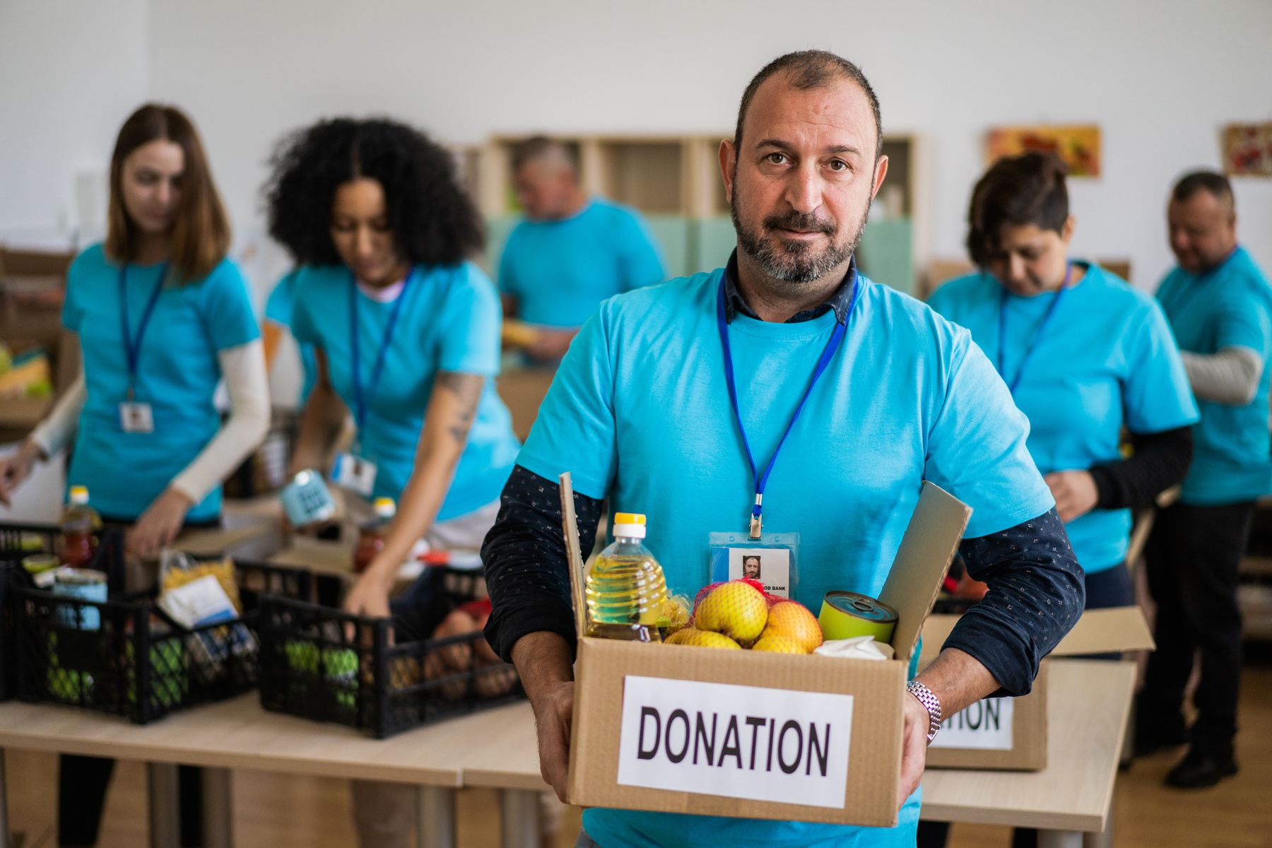 A charity worker with a charity grocery box